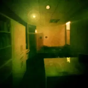 Farbenfrohes grünstickiges Bild zeigt ein Zimmer